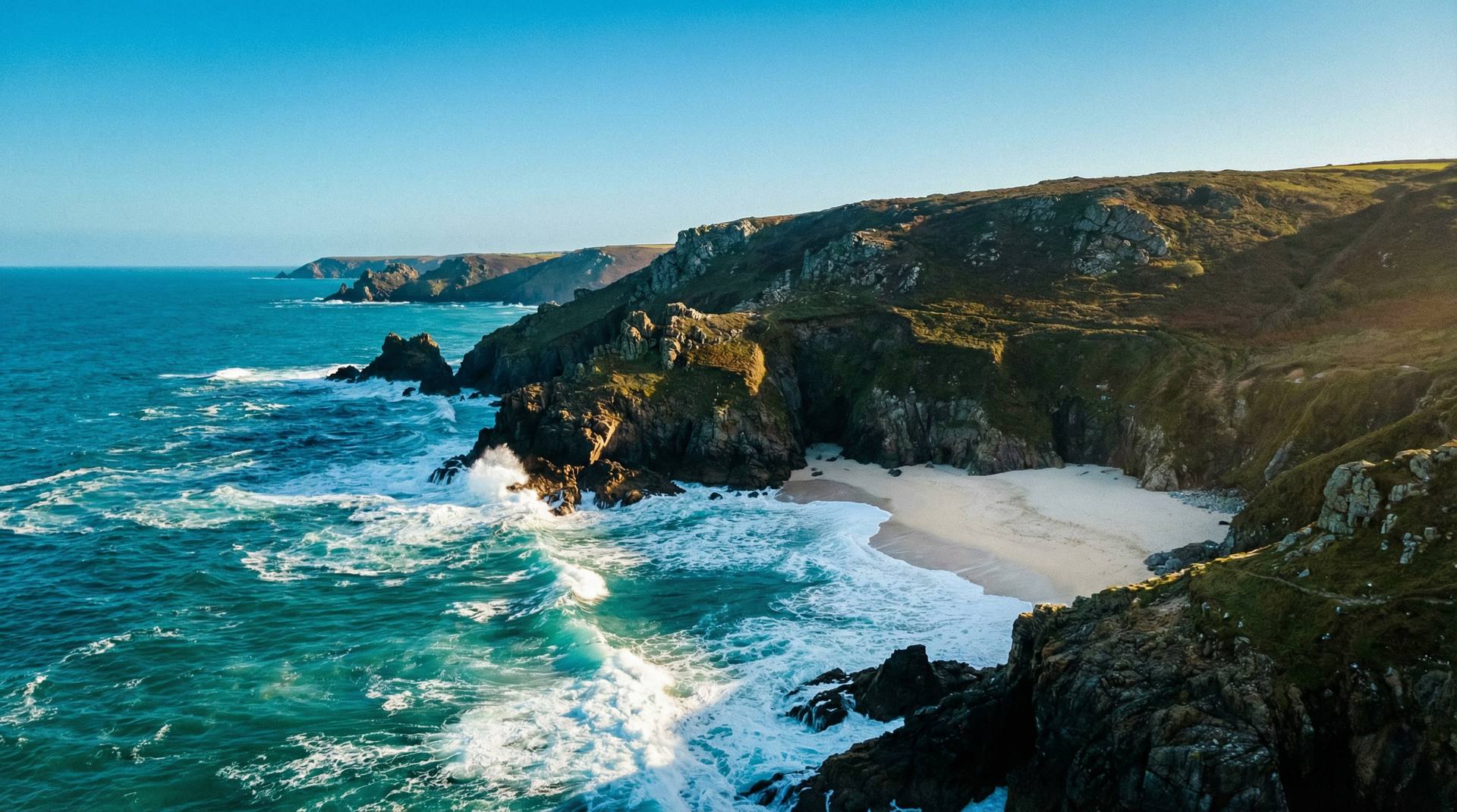 Dramatic Cornwall coastline with turquoise sea and white sandy cove